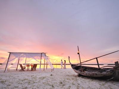 Spiaggia con tenda e barca al tramonto