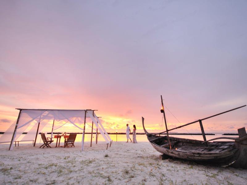 Spiaggia con tenda e barca al tramonto