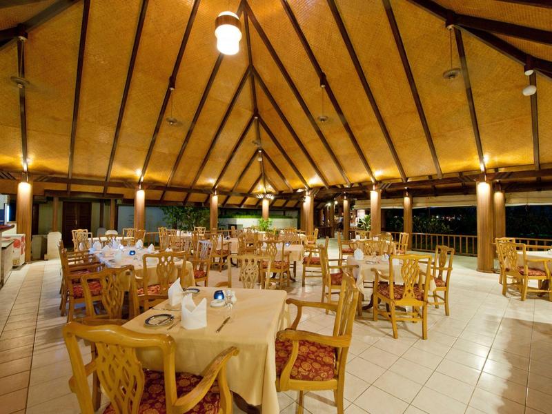 Großer, offener Speisesaal mit Holztragwerk und gedeckten Tischen in einem Hotel.