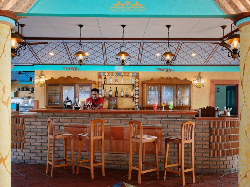 Gemütliche Hotelbar mit Holzstühlen, einer Marmor-Theke und entspannter Beleuchtung.