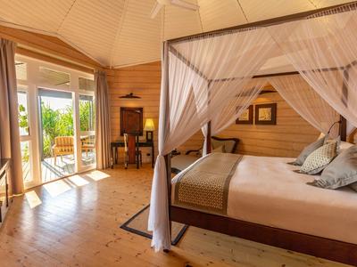 Gemütliches Schlafzimmer mit Himmelbett, Holzwänden und direktem Zugang zur Terrasse.