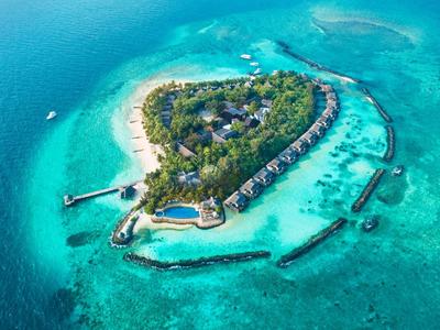 Vue aérienne d'une île tropicale avec bungalows au-dessus de l'eau et mer turquoise claire