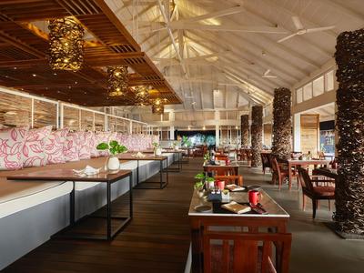 Intérieur de restaurant moderne avec sols en bois, banquettes confortables et luminaires décoratifs au plafond