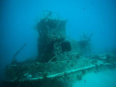 Épave immergée recouverte d'algues sur le fond marin dans une eau bleu clair