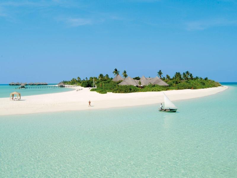 Kleine tropische Insel mit Sandstränden und klarem Wasser unter blauem Himmel