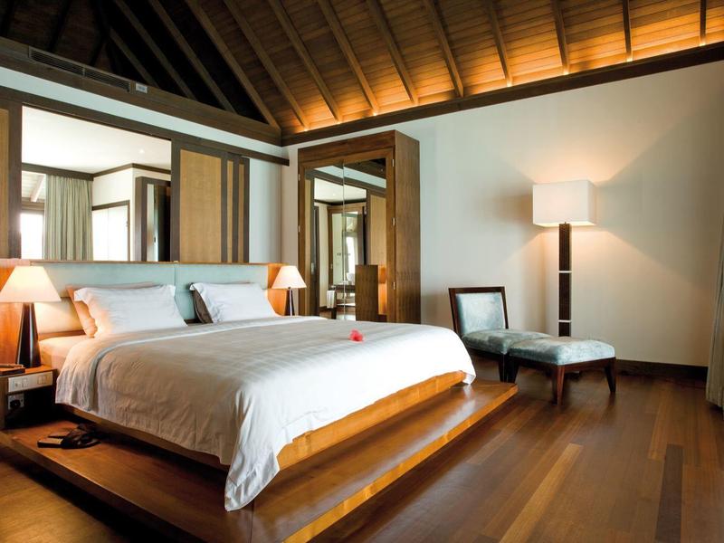 Modernes Schlafzimmer mit großem Bett, Holzboden, warmem Holzdecke und viel natürlichem Licht.