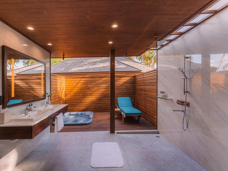 Modernes Badezimmer mit Dusche, Doppelwaschbecken, Whirlpool und Holzdecke.