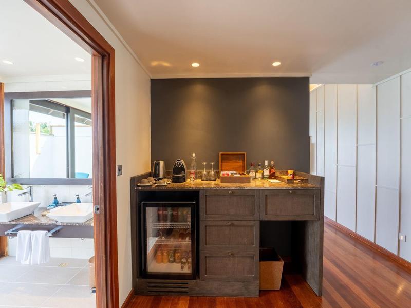 Moderner Hotel-Zimmerbereich mit Minibar und Blick ins Badezimmer