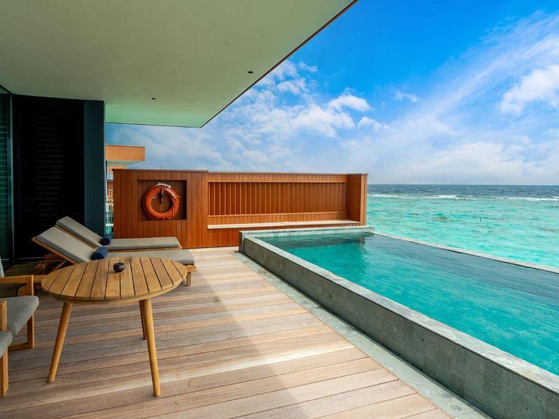 Luxuriöse Terrasse mit Pool und Blick auf türkisfarbenes Meer unter blauem Himmel