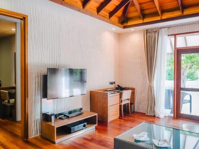 Gemütliches Hotelzimmer mit Holzfußboden, Fernseher, Schreibtisch und Zugang zu einem Balkon.