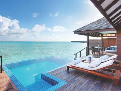 Luxuriöse Terrasse mit Infinity-Pool und Aussicht auf das blaue Meer bei klarem Himmel.