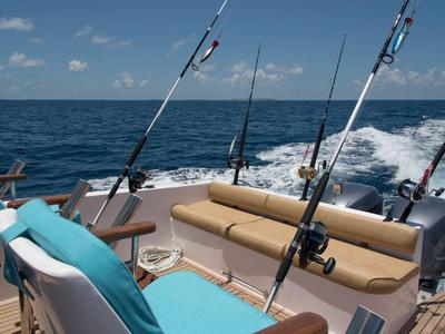 Boot mit Angelruten am Meer an einem sonnigen Tag