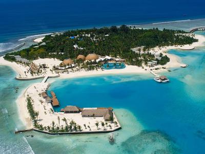 Tropische Insel mit weißem Sandstrand, türkisfarbenem Wasser und grüner Vegetation.