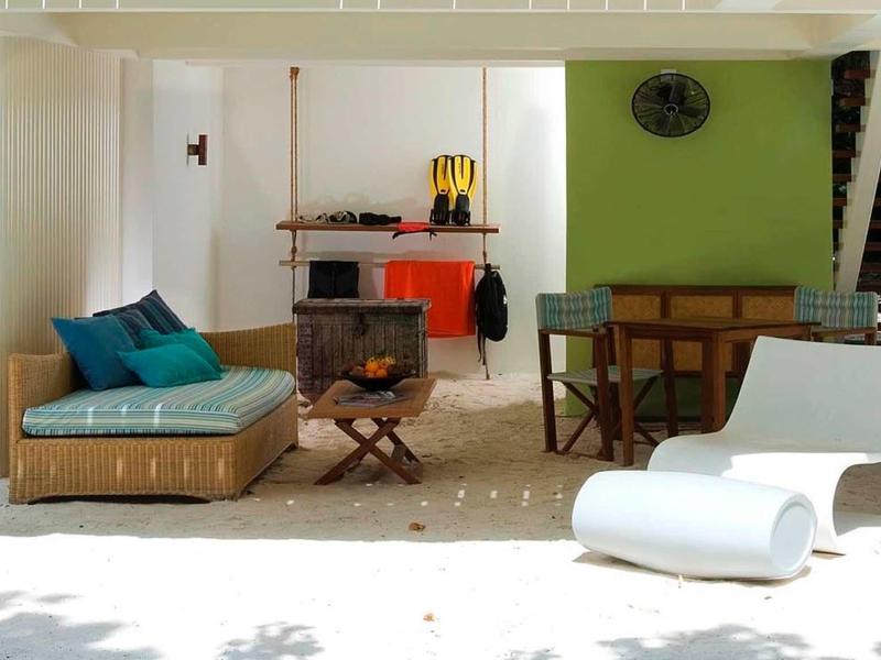 Moderne Terrasse mit weißem Boden, grünem Wandakzent, Holzmöbeln und gemütlicher Loungeecke.