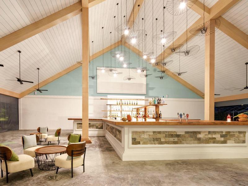 Heller, moderner Gastraum mit Holzbalken, stilvoller Bar und gemütlichen Sitzgruppen.