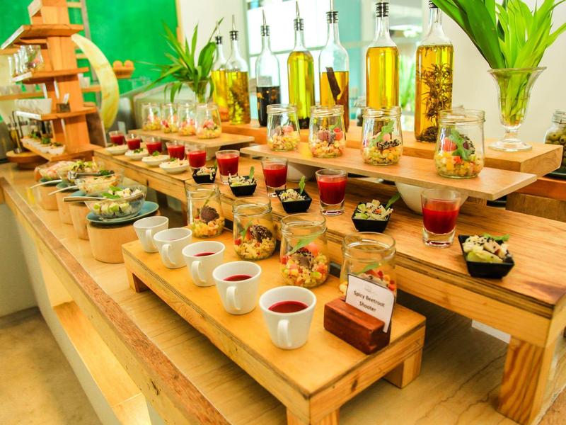 Buffet mit kleinen Vorspeisen, Saucen und Olivenöltropfen auf mehrstufigen Holzplatten.