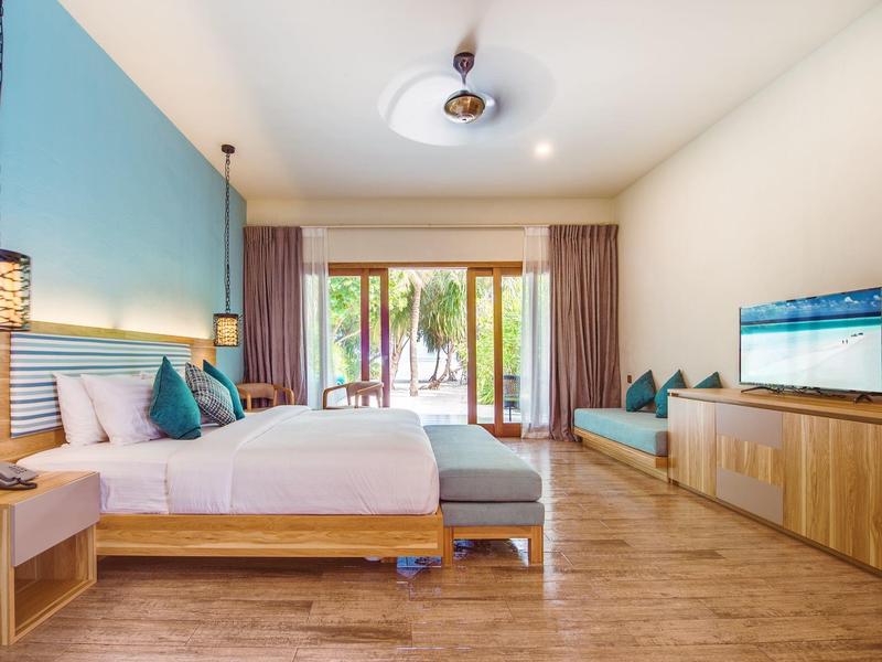 Modernes Schlafzimmer mit großem Bett, Holzboden, Flachbildschirm und Fensterfront mit Vorhängen.