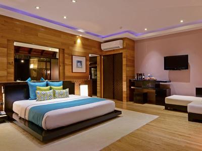 Modern eingerichtetes Hotelzimmer mit großem Bett und gemütlicher Sitzecke.