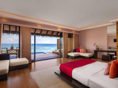 Geräumiges Hotelzimmer mit Meerblick, großem Bett, Sitzbereich und Zugang zur Terrasse mit Meerblick.