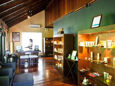 Innenraum eines gemütlichen Hotels mit Holzboden, Regalen mit Produkten und Sitzbereichen.