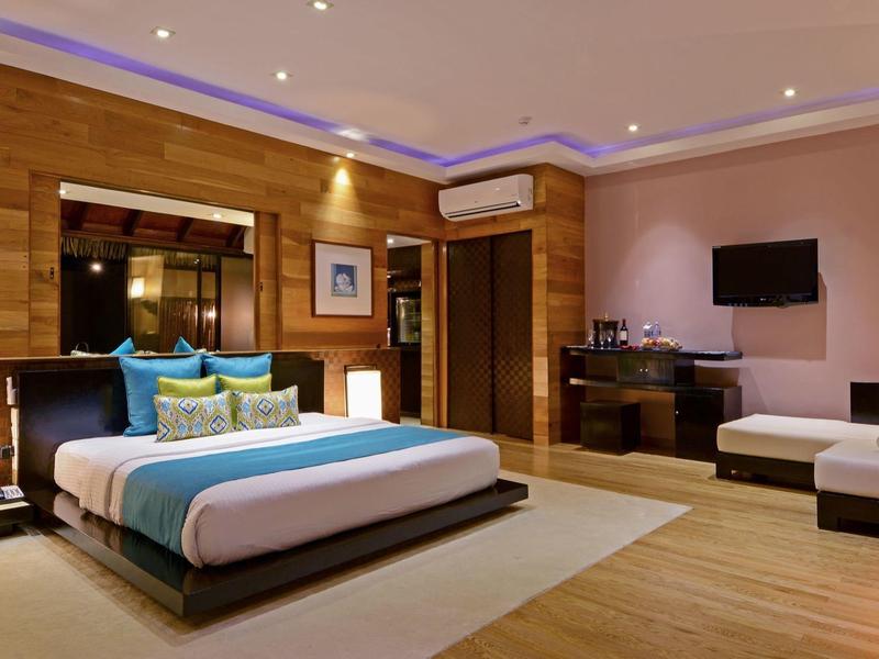 Modern eingerichtetes Hotelzimmer mit großem Bett und gemütlicher Sitzecke.