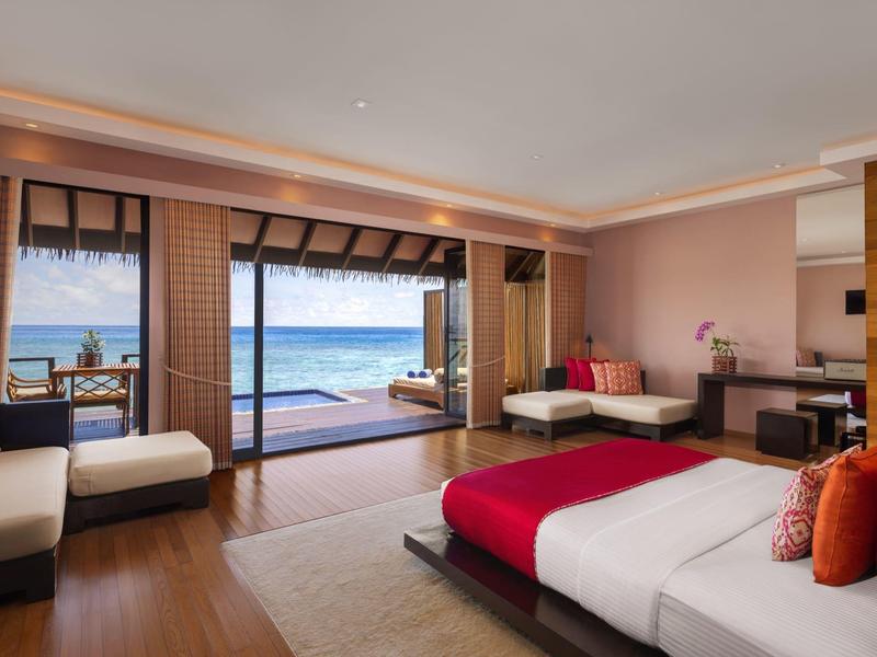 Geräumiges Hotelzimmer mit Meerblick, großem Bett, Sitzbereich und Zugang zur Terrasse mit Meerblick.