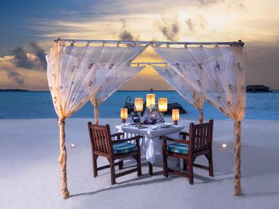Dîner romantique sous un auvent sur la plage au coucher du soleil