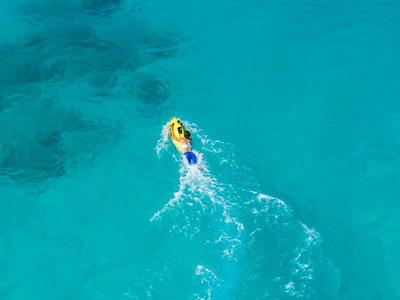 Personne sur une planche à pagaie sur une eau océanique claire et bleue