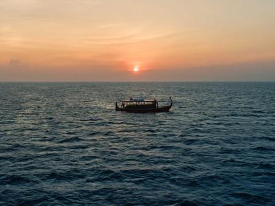Petit bateau sur mer calme au coucher du soleil