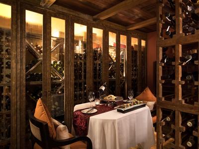 Cave à vin conviviale avec mobilier en bois rustique et table dressée pour deux.