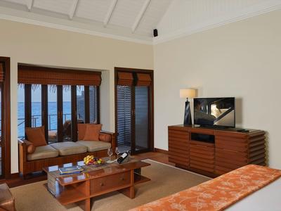 Chambre d’hôtel confortable avec meubles en bois, coin salon et vue sur la mer