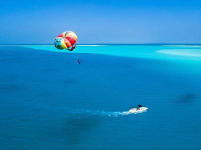 Vue de parachute ascensionnel au-dessus de la mer turquoise avec un bateau en dessous