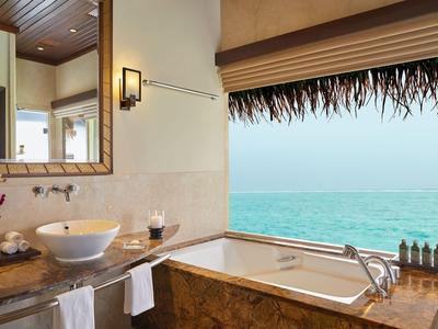 Salle de bain luxueuse avec une baignoire indépendante et vue sur la mer.