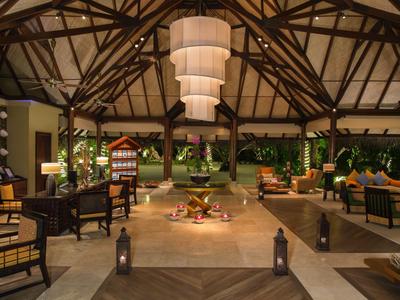 Hall d'hôtel accueillant avec poutres en bois hautes, canapés et éclairage chaleureux