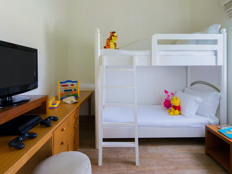 Hotelzimmer mit Etagenbett, Spielzeug und Fernseher auf einem Holzschrank