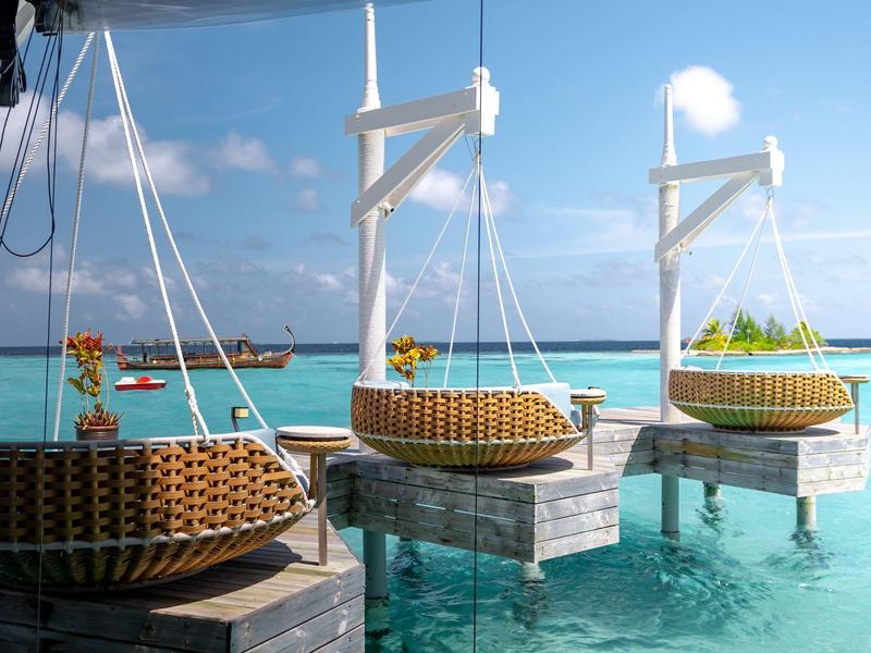 Schwimmende Sitzbereiche mit Panoramablick auf türkisfarbenes Meer und Inseln im Hintergrund
