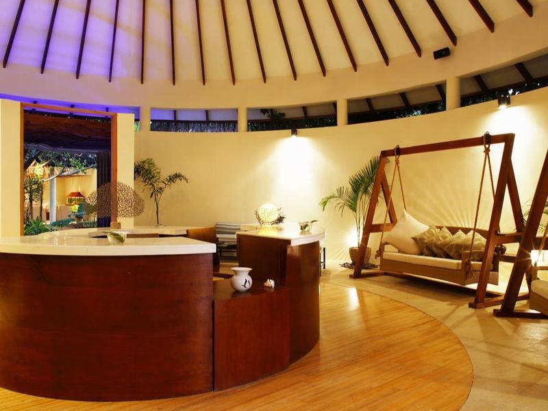 Innenansicht eines modernen Spa-Raums mit Holzverkleidung, Hängesesseln und gedämpfter Beleuchtung.