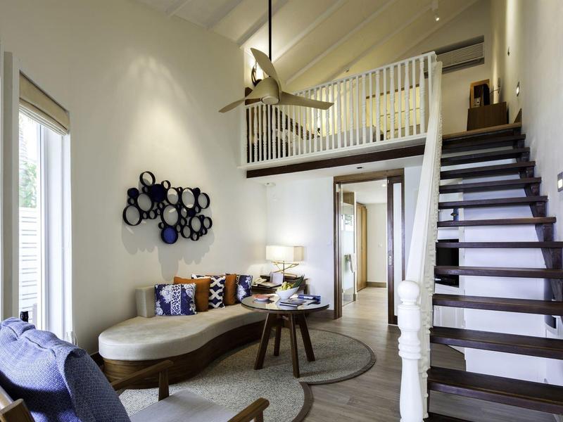 Wohnzimmer mit modernen Möbeln, Treppe zur Galerie, Holzfußboden und runder Teppich.