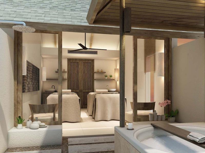 Moderner Raum mit Massagetischen und Badewanne, warm beleuchtet und mit Holzdetails.