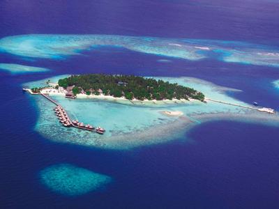 Piccola isola tropicale con bungalow sulla spiaggia e acqua azzurra limpida