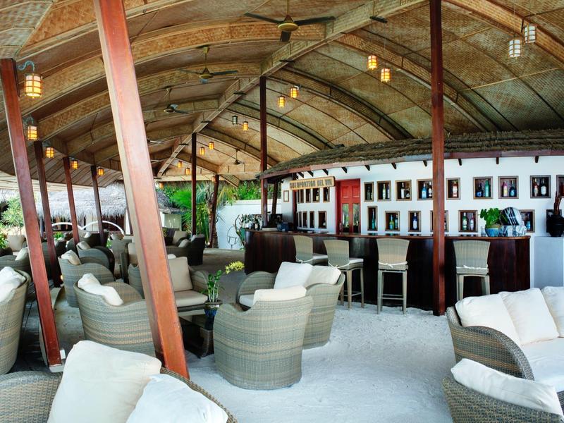 Offenes, überdachtes Lounge-Schiff mit weißen Rattanmöbeln und gemütlichen Sitzgruppen.