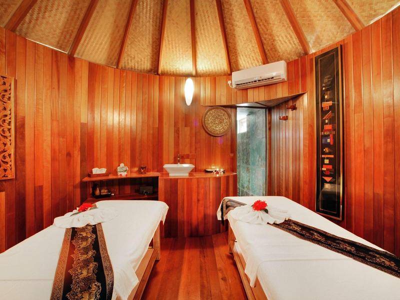 Gemütlicher Holzzauber mit zwei Massageliegen, warmes Licht und dezente Dekoration.