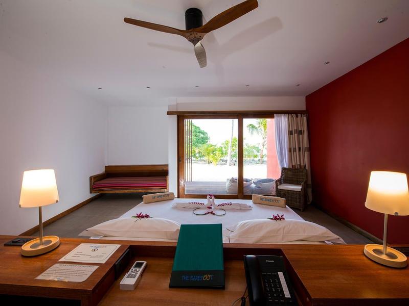 Modernes Schlafzimmer mit Holzdecke, Doppelbett, roten Wänden und großen Fenstern zum Garten.