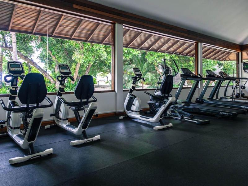 Fitnessraum mit mehreren Cardiogeräten wie Fahrradergometer und Laufbänder vor großen Fenstern.