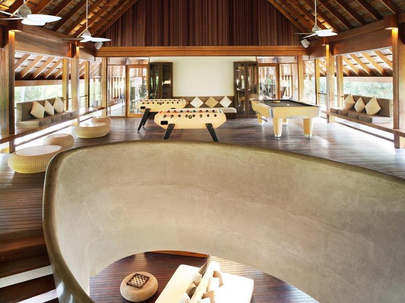 Moderner Hotel-Loungebereich mit geschwungener Treppe und Sitzecke unten.