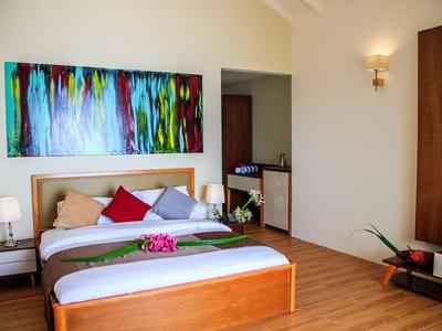 Modernes Hotelzimmer mit großem Bett, buntem Gemälde und Holzboden.