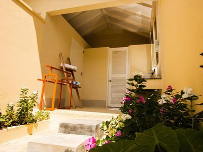 Eingangsbereich mit gelben Wänden, weißen Türen und Pflanzen am Treppenaufgang.