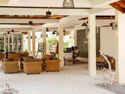 Helle, offene Lounge mit Korbsesseln und gepolsterten Sitzgelegenheiten in einem Hotel.