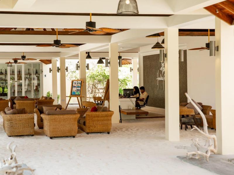 Helle, offene Lounge mit Korbsesseln und gepolsterten Sitzgelegenheiten in einem Hotel.