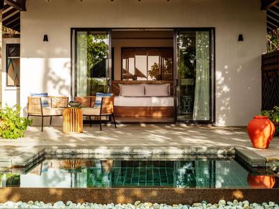 Przytulny taras z miejscami do siedzenia i prywatnym basenem przed pokojem hotelowym.